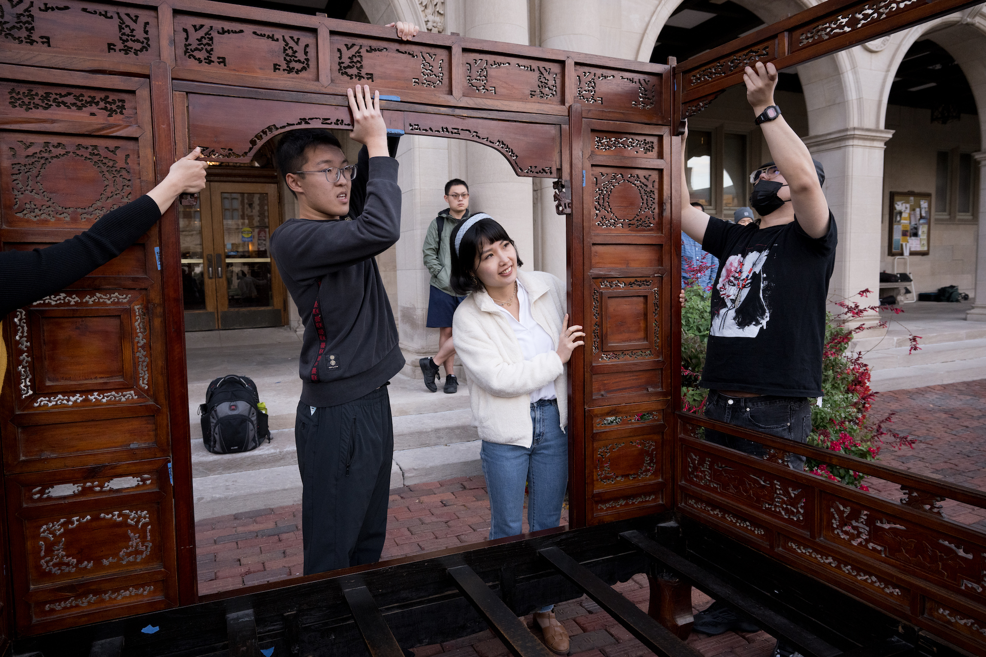 Students help transport a Qing era bed