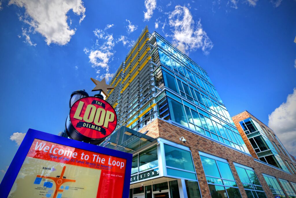 Exterior on corner looking up at blue sky with Loop map sign in foreground.