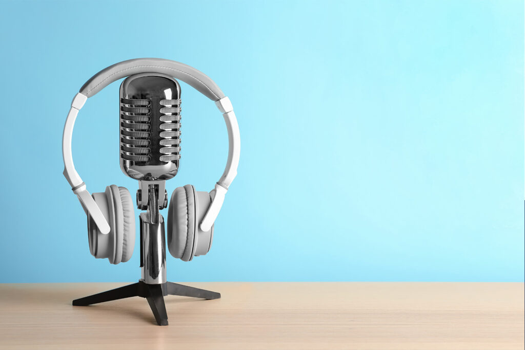 Retro microphone and headphones on table against blue wall